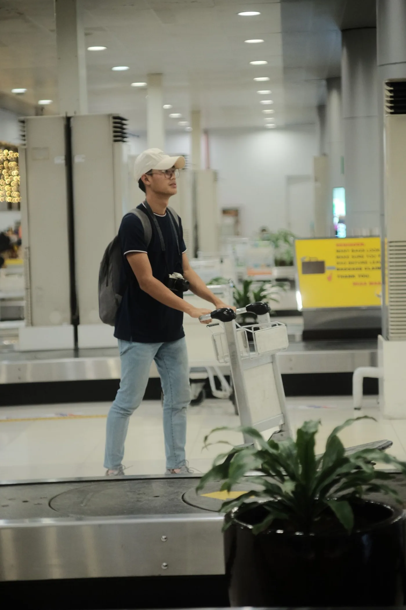 Hành khách sử dụng xe đẩy tại khu nhận hành lý — minh họa gói nhập cảnh và hỗ trợ hành lý