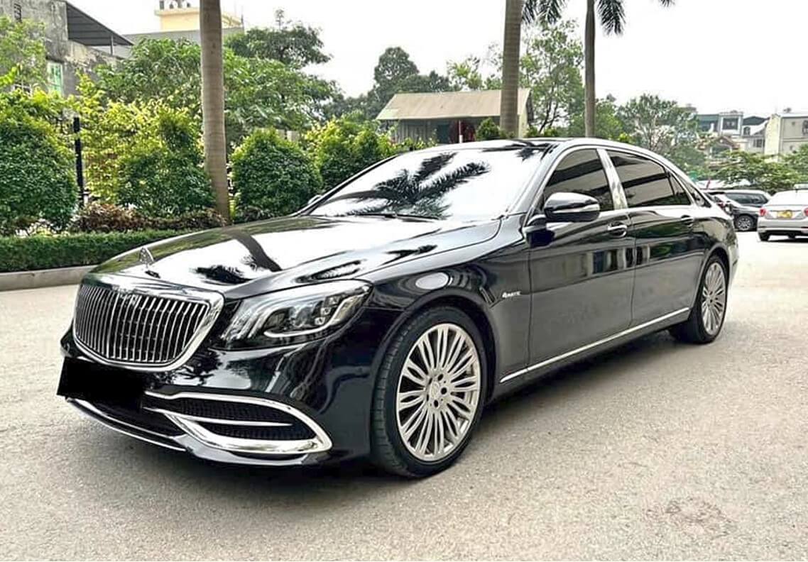 Black Mercedes-Benz sedan on a tree-lined street