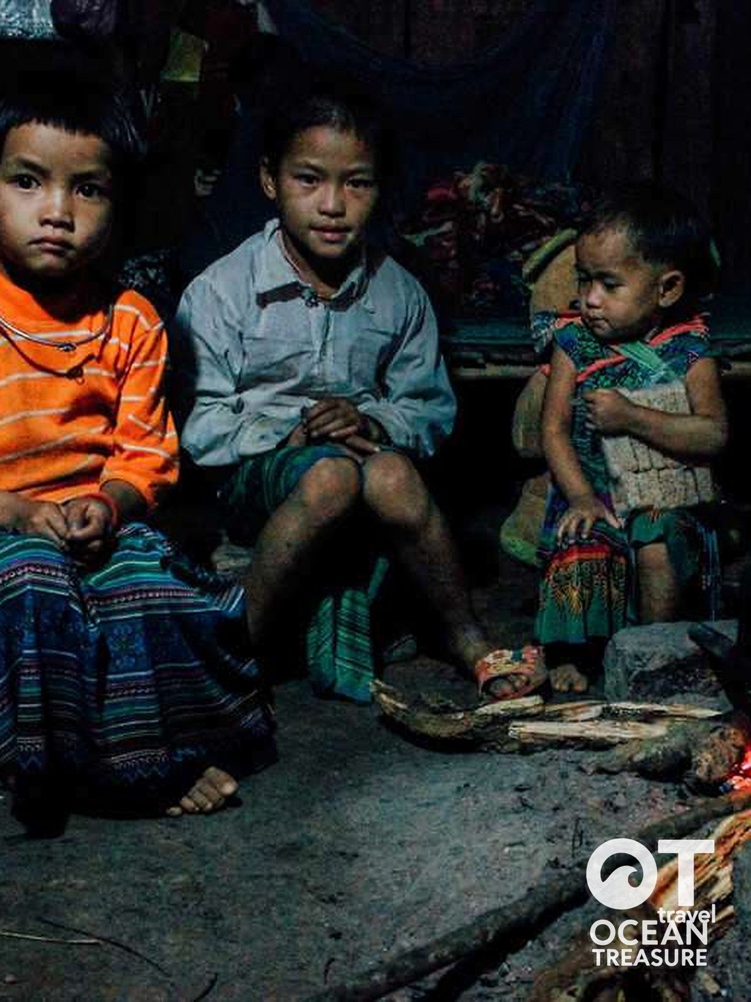 Trẻ em người Mông ngồi cạnh bếp lửa trong nhà.