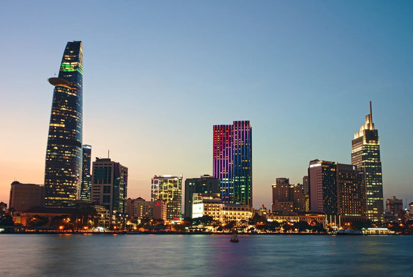 Bitexco Financial Tower and District 1 high-rises along the Saigon River at dusk, seen from Thu Thiem, Ho Chi Minh City