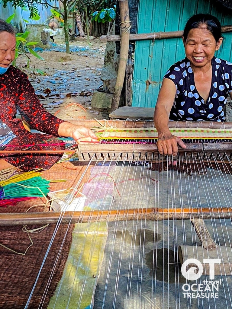Hai nghệ nhân trình diễn dệt chiếu trên khung tay tại làng Cẩm Nê.